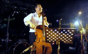 a rear view picture of rock star yoyo ma performing on stage to a large audience